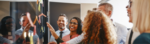 Group of people brainstorming around a board