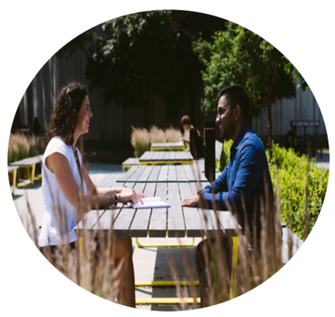 Man and woman talking while sitting at an outdoor seating area