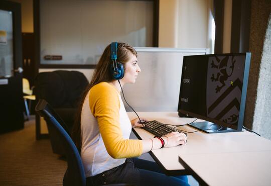 Girl using computer with headphones