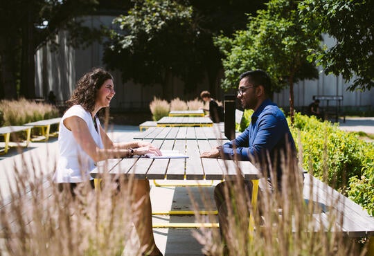 Man and woman talking at an outdoor table