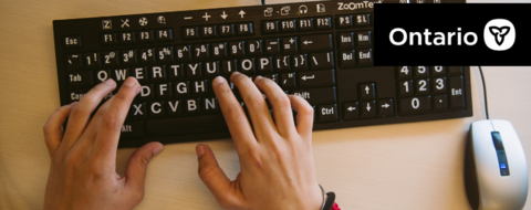 Hands typing at an accessible keyboard, overlayed by the Ontario government logo