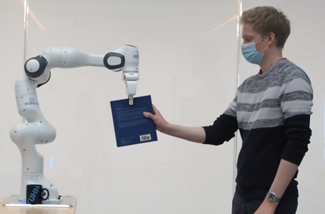 Robot handing a book to a user