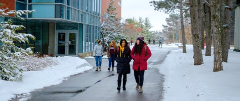 Students in winter coats walk through a snowy University of Waterloo campus