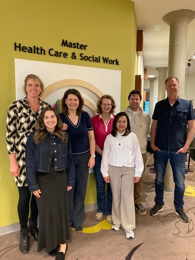 CCTS members from Saxion University and two students from University of Waterloo standing in front of reception area at Saxion University