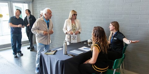 Volunteers talking to people at an information desk