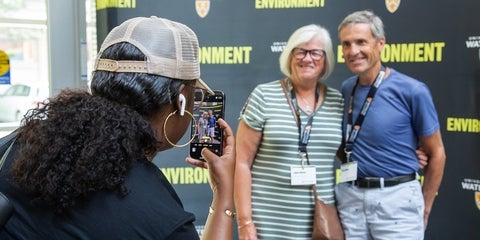 Volunteer taking a picture of two people