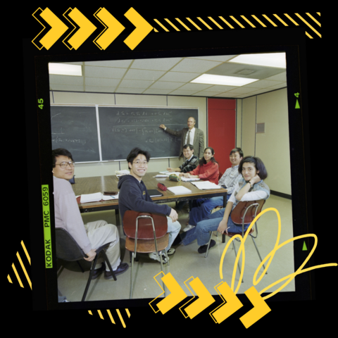 Group of students sitting at a table in a classroom on film with yellow graphics in the background