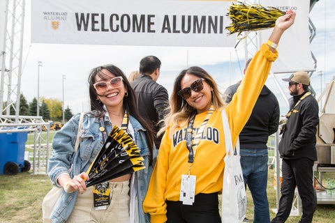 Two alumni cheering at homecoming