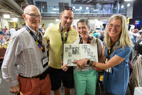 Alumni pointing to photo in yearbook