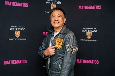 An alum points at the Waterloo crest on his leather jacket