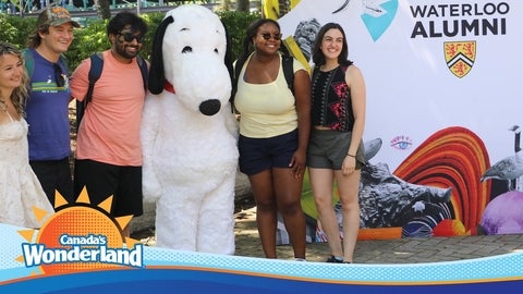 Five people posing with a life-sized Snoopy