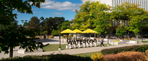 university of waterloo sign with a person walking by