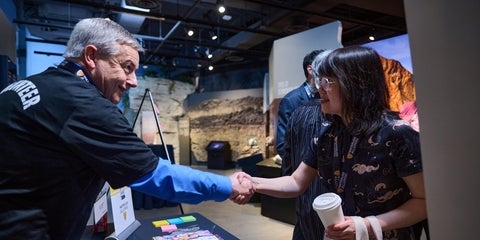 UWaterloo alumni smiling and shaking hands