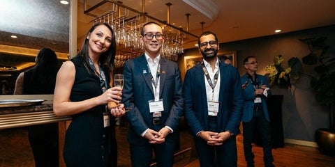 Three UWaterloo alumni smiling at the camera