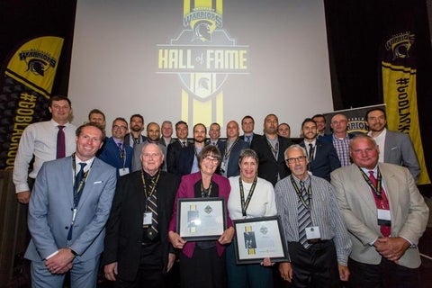Warriors Hall of Fame award recipients in front of a stage