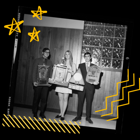 Three people holding awards captured on film with yellow graphics in the backgroudn