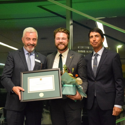 Andrew James Zettel smiles with his award