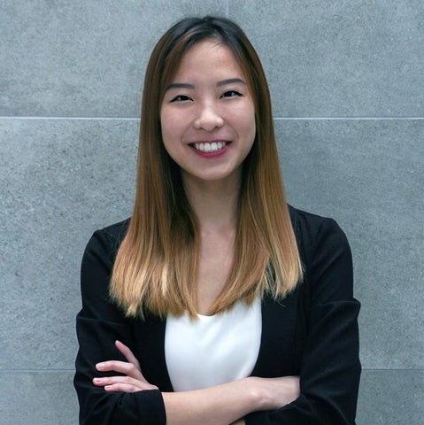 Image of Szwina (Hong Kong chapter member) standing in front of a grey wall crossing her arms