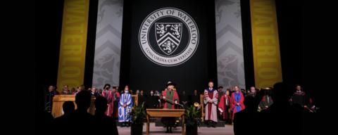 convocation ceremony with lady in convocation regalia holding uwaterloo mace