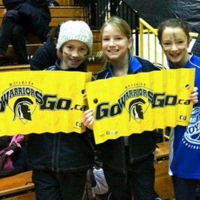Three young girls holding "Go Warriors Go" signs