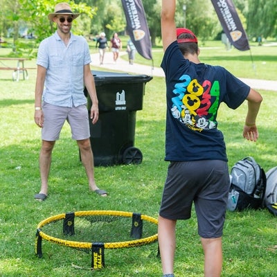 Two attendees playing spike ball