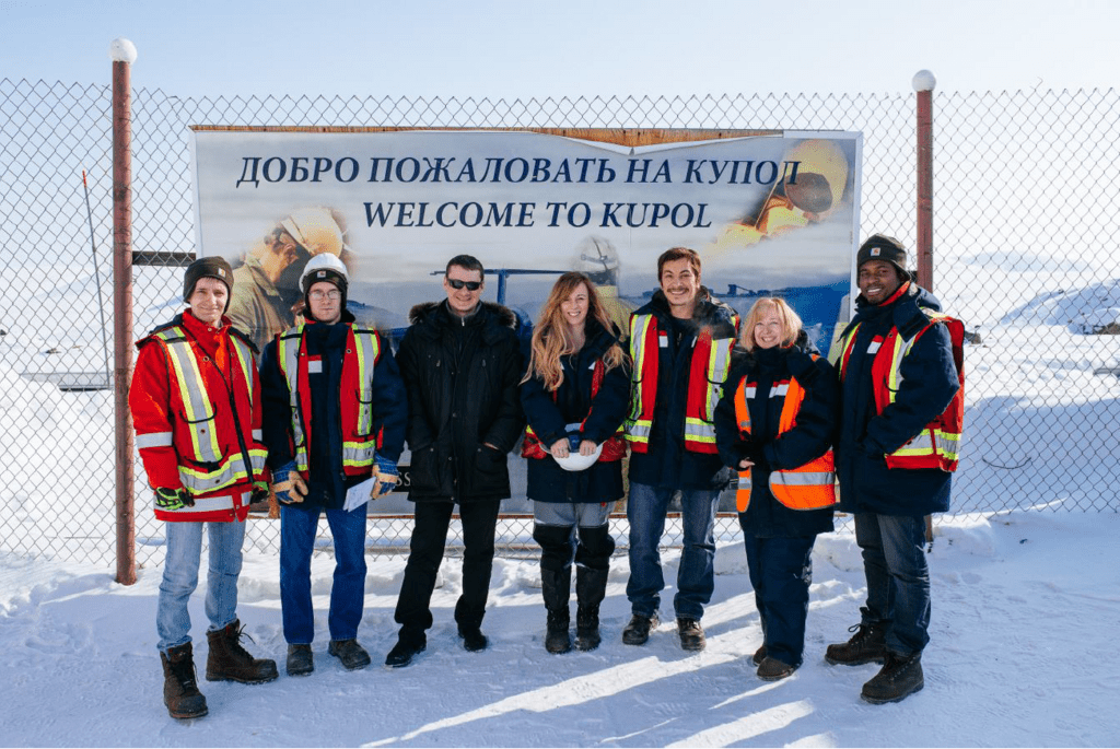 Carlie and her team at the "Welcom to Kupol" sign