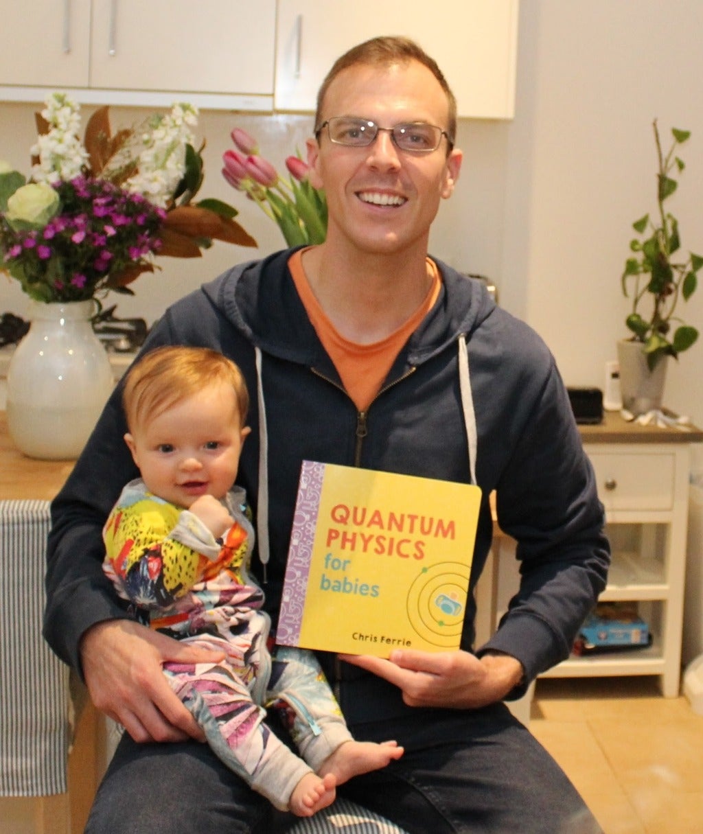 Chris with his baby and the 'Quantum Physics for Babies' book