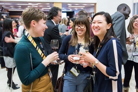 Alumni laugh together at an event