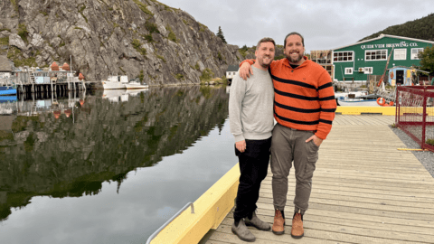 Franco Solimano and Spencer Small standing on a pier with mountains in the distance