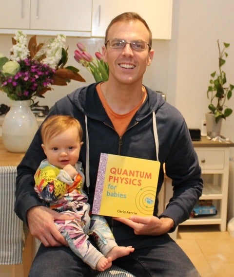 Chris with his baby and the 'Quantum Physics for Babies' book