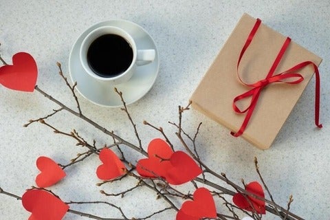 Coffee, notebook and paper hearts on branch