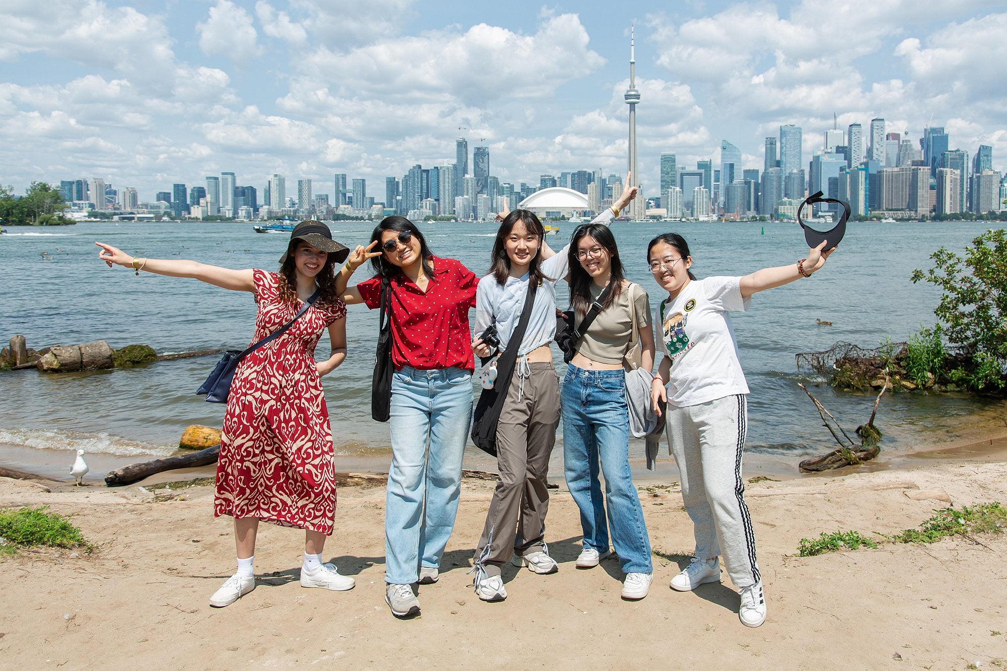 Five people posing for a group photo in front of the Toronto skyline