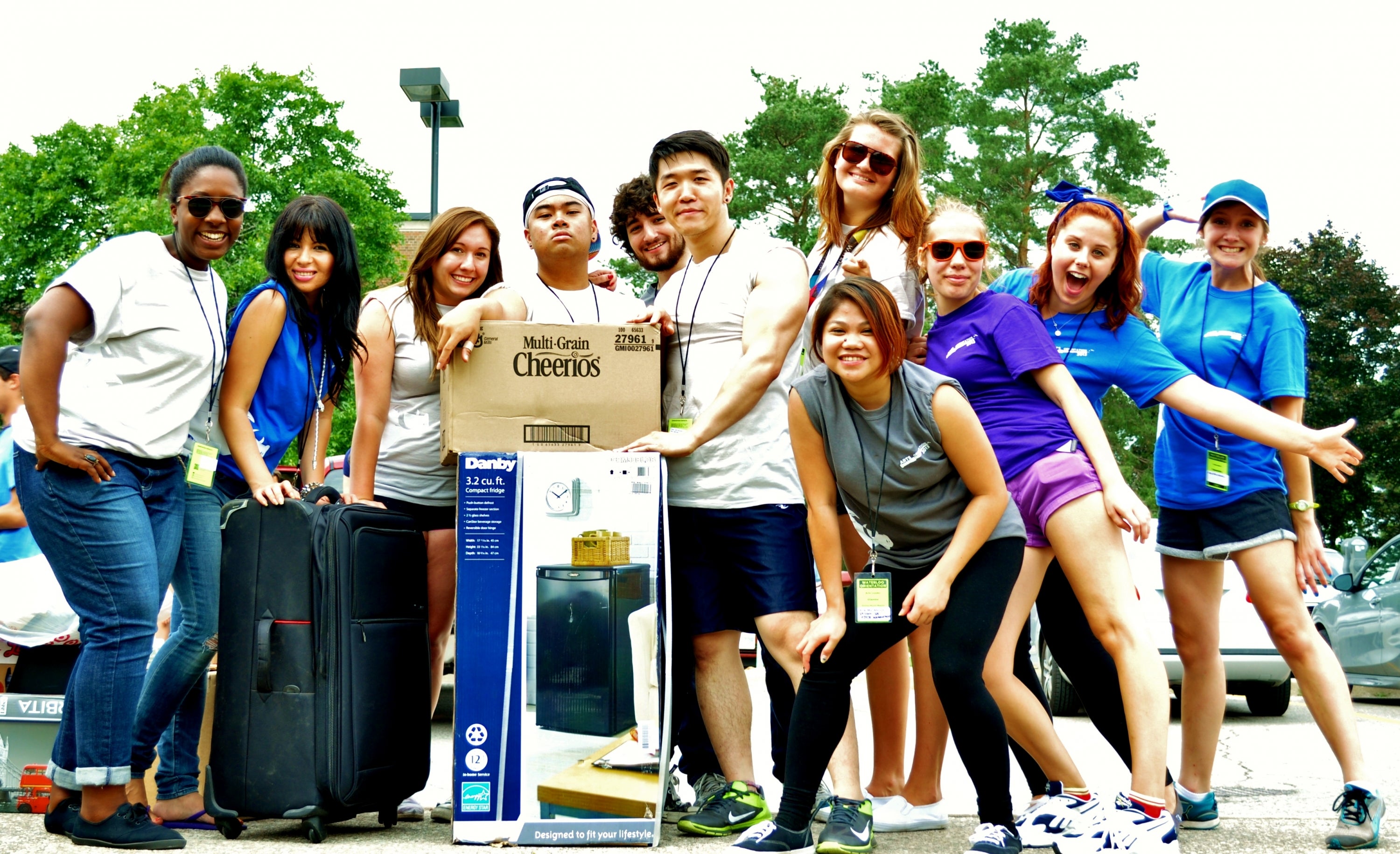 A group of enthusiastic students gather around luggage.
