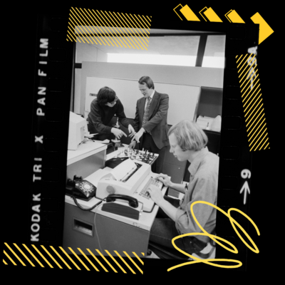A student using a typewriter while two people look at a chessboard in the background captured on film
