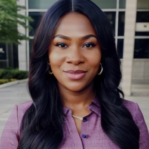 A black woman with long black wavy hair smiling in a selfie