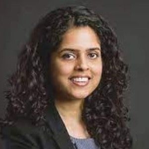 Image of Snehal (UAE alumni chapter) standing in front of a grey backdrop, smiling