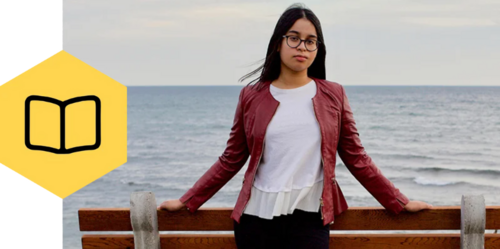 Person standing in front of the ocean with a book icon on the left