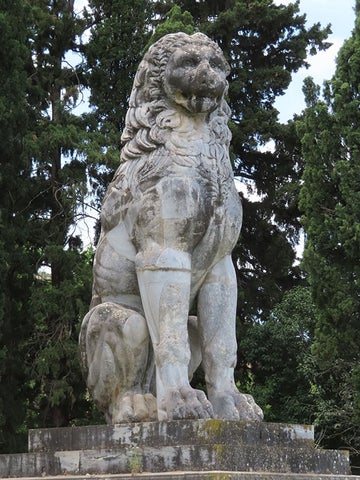 Lion monument sculpted in a Classical style with extra long legs and a cat-like face