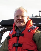 Robert W. Park wearing a life vest in front of a helicopter