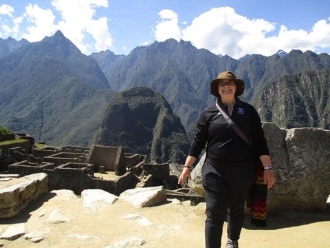 Robyn Wood at a dig site with mountains in the background