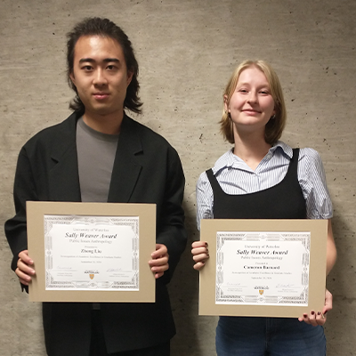 Award recipients, holding their awards and smiling