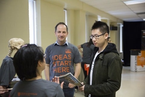 Dr. Götz Hoeppe and current student talking to prospective student