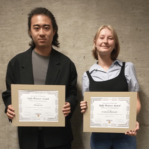 Award recipients, holding their awards and smiling