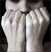A person with anxiety covering their mouth with their hands
