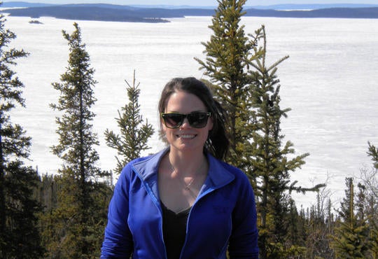 Allison Holmes standing at frozen river bank in Northwest Territories.