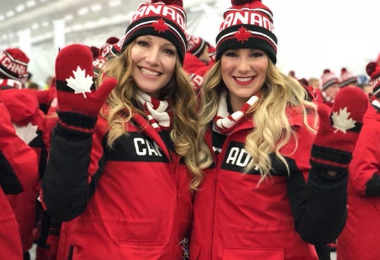 Heather Moyse with Alysia Rissling wearing Canada coats at Olympics.