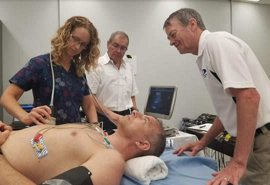 Richard Hughson and team perform ultrasound test on an astronaut.