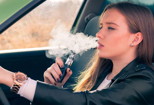 Young person vaping in car.