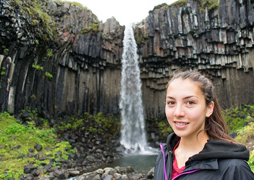 Lizz Webb standing in front of a waterfall