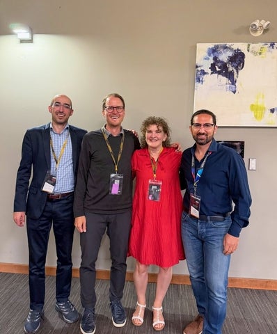 3 men and one women posing for photo